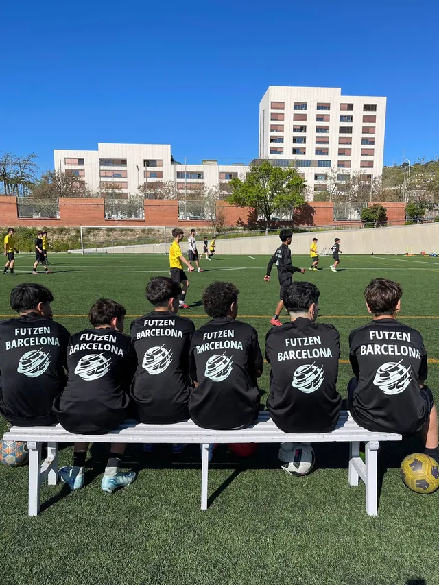 Jugadores de FUTZEN sentados en el banquillo, de espaldas, mirando un partido