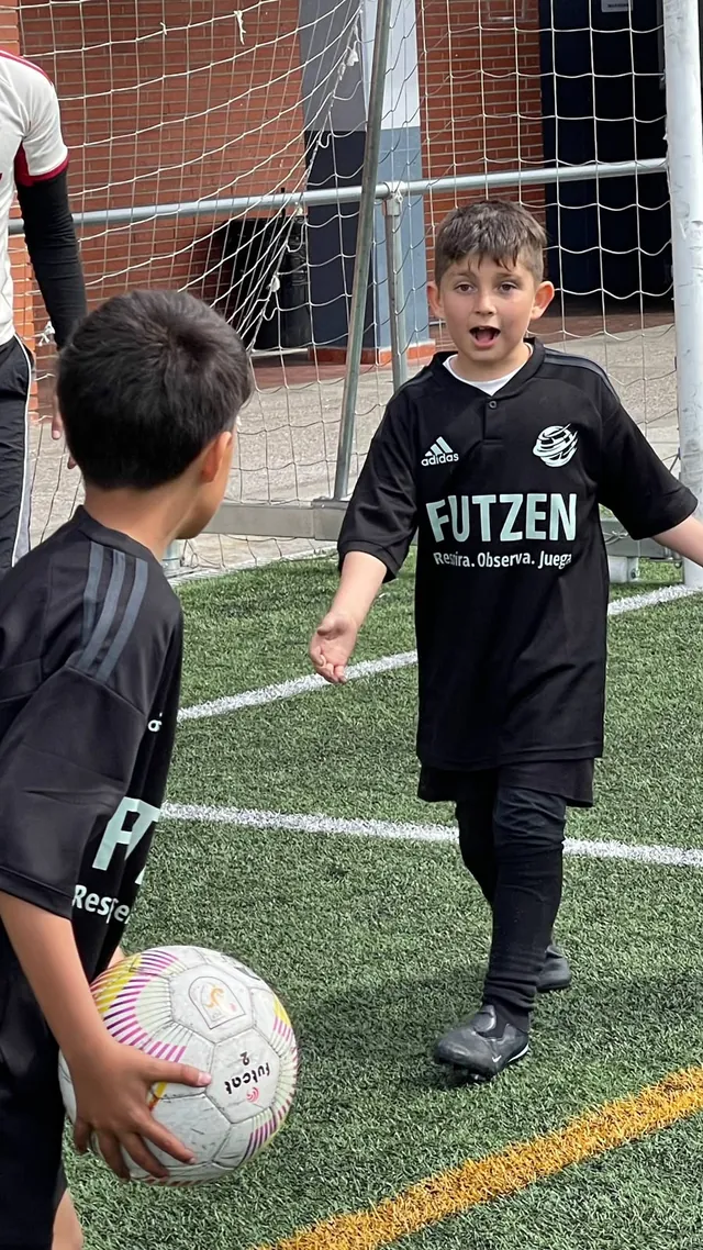 Un niño con la camiseta de FUTZEN celebra delante de la portería